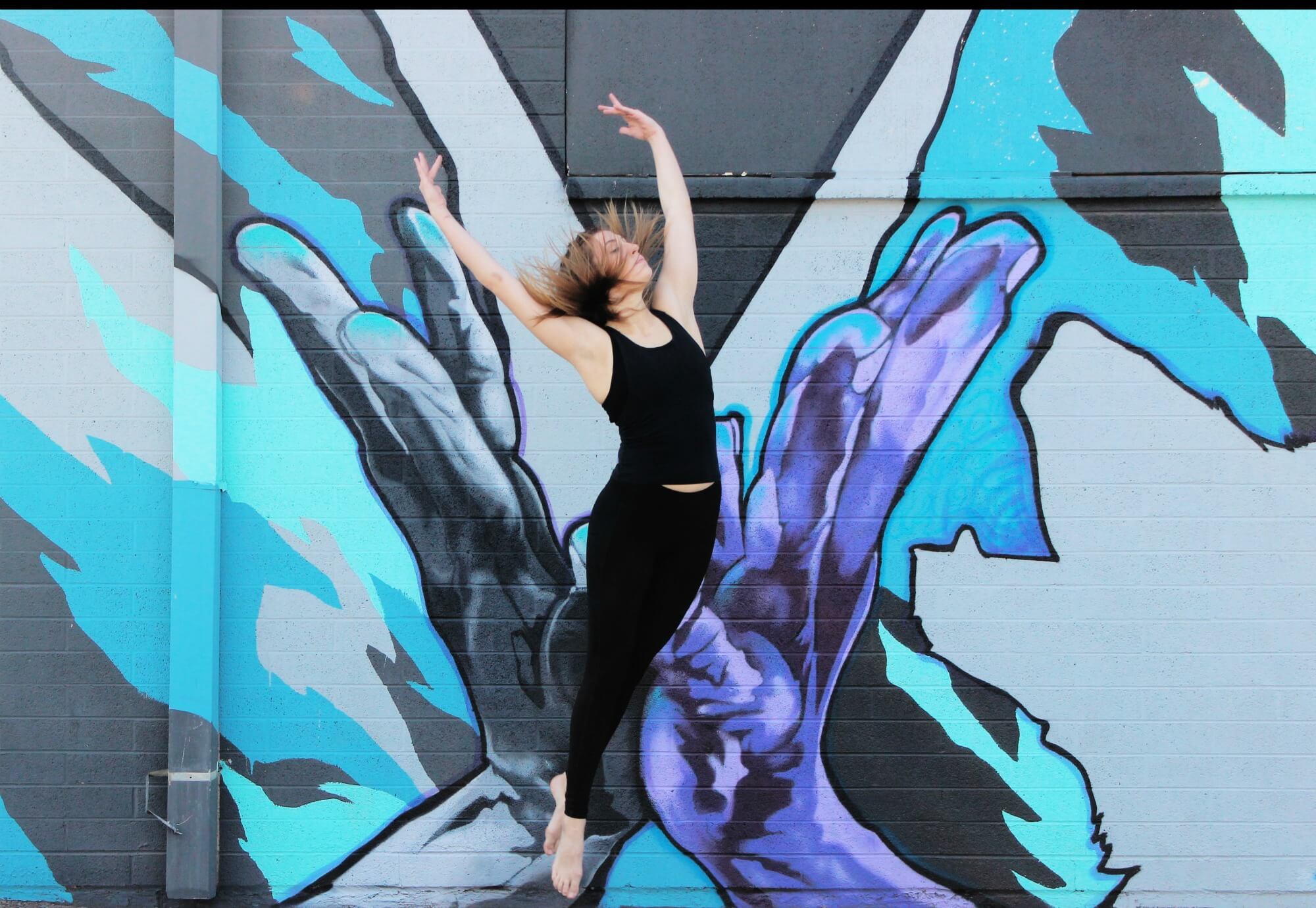 Dancer Randee Powell in front of a mural by Joerael JE. Photo: Ashley Baker.